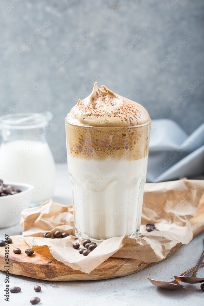 Dalgona creamy coffee in a glass on a light gray background with whipped foam. Korean food trend, Vertical format Dalgona creamy coffee in a glass on a light gray background with whipped foam. Korean food trend, Vertical format