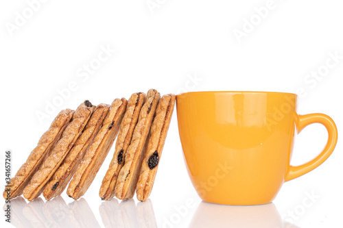 Lot of whole square puff cookie with raisins with yellow cup isolated on white