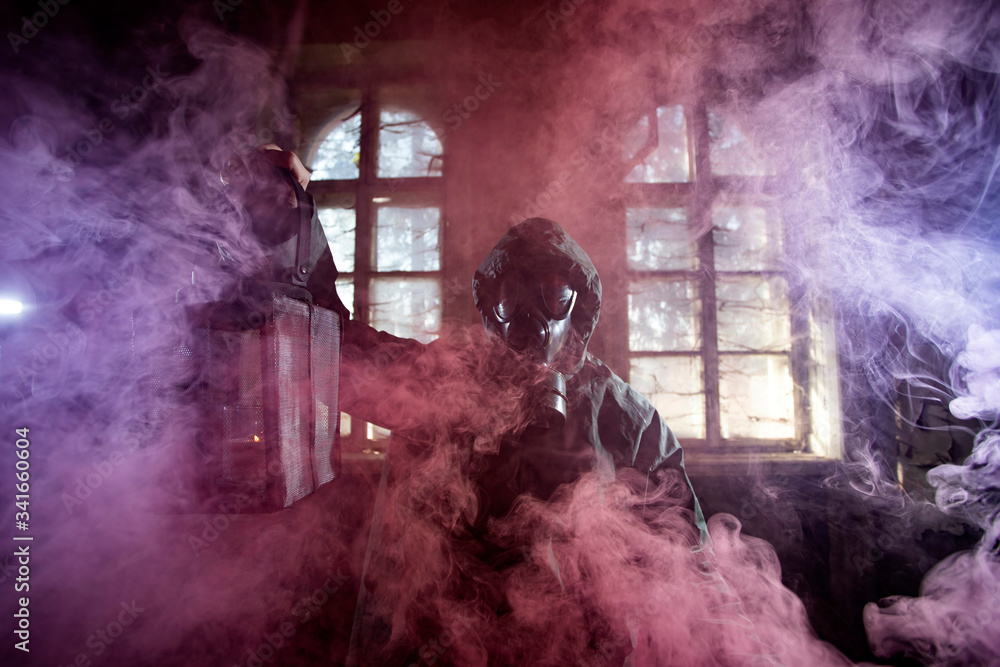 Obraz premium Dramatic portrait of a woman wearing a gas mask in a ruined building.