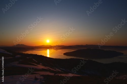 The rising sun illuminating Lake Kussharo. Scenery of dawn from Bihoro Pass. Hokkaido, Japan.