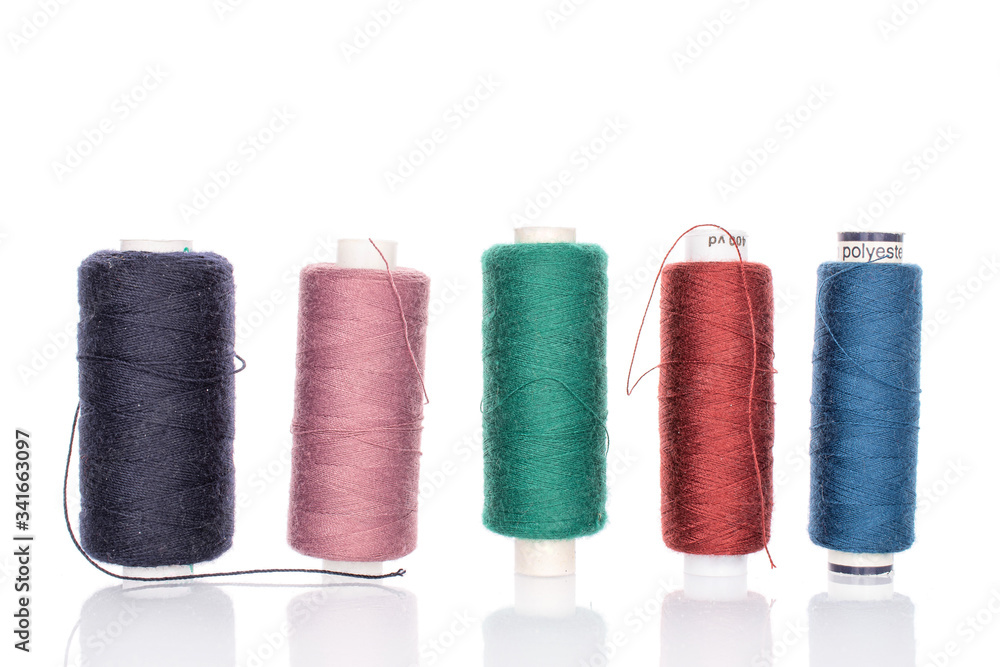 Group of five whole thread spools in row isolated on white Group of five whole thread spools in row isolated on white