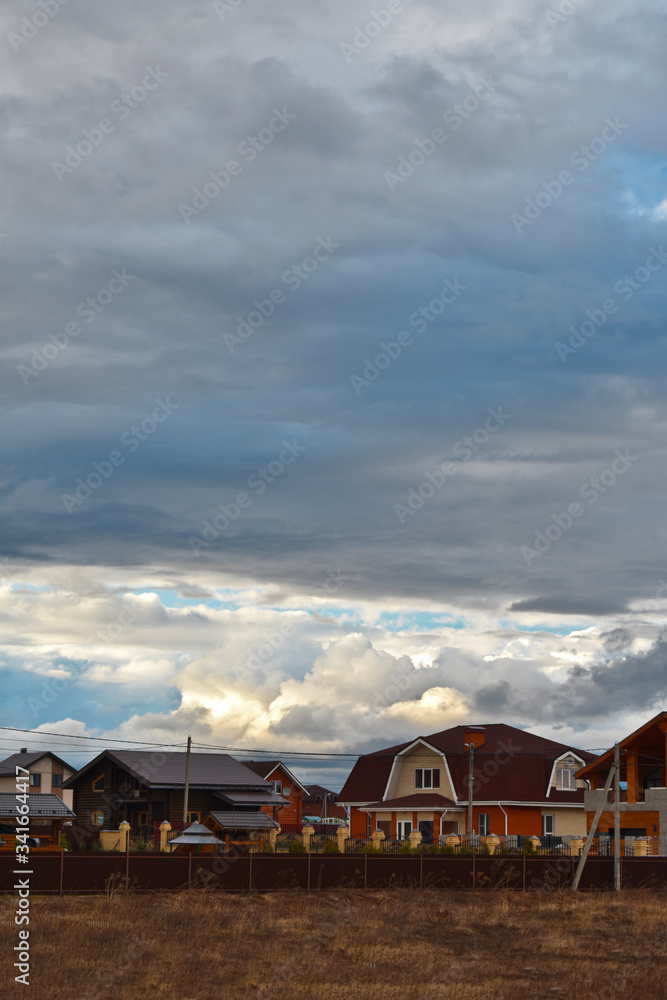 clouds over houses in a cottage settlement