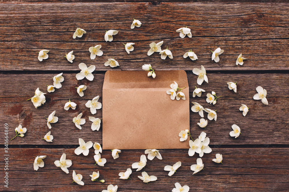 Jasmine flowers in an envelope on a wooden background.