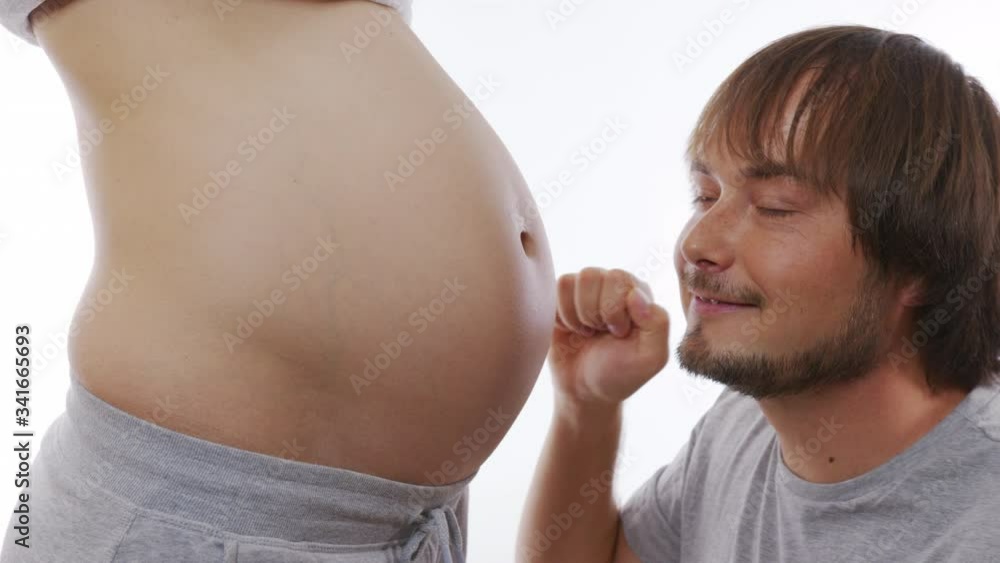 A man banging on the belly of a pregnant woman. Happy family. A man kisses a pregnant woman. Closeup, 6k. A man banging on the belly of a pregnant woman. Happy family. A man kisses a pregnant woman. Closeup, 6k.