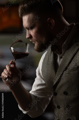 Professional sommelier man with a glass of red wine.