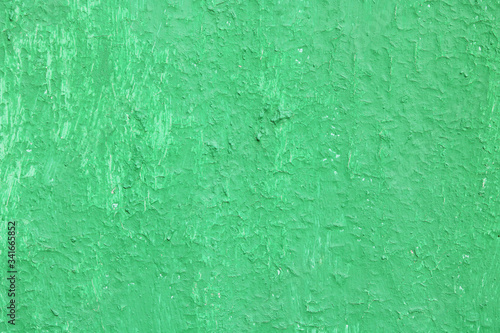 Beautiful vintage green background with old green paint with a rough surface, streaks and uneven texture of green paint on an old rough surface