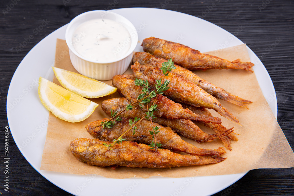 Fried drum on coal, served with lemon and sour cream Fried drum on coal, served with lemon and sour cream