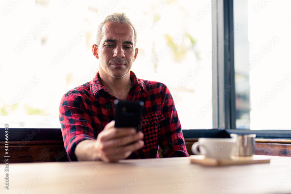 Portrait of Persian man using phone at the coffee shop Portrait of Persian man using phone at the coffee shop