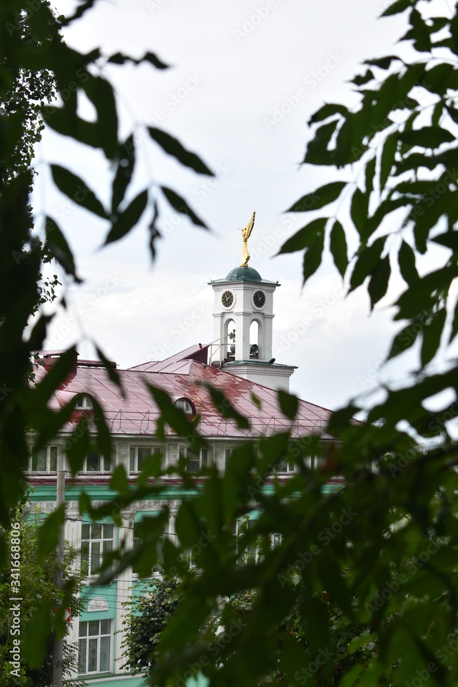 view of the Orthodox Church through the green leaves of trees