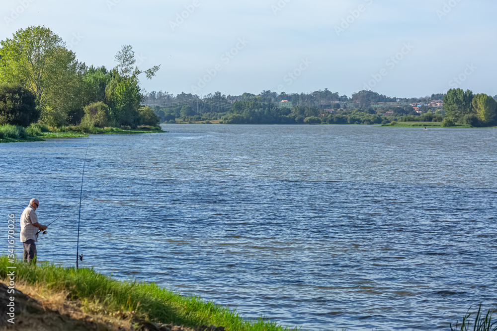 View at the lake of Pateira Fermentelos, landscape around and a man fishing on