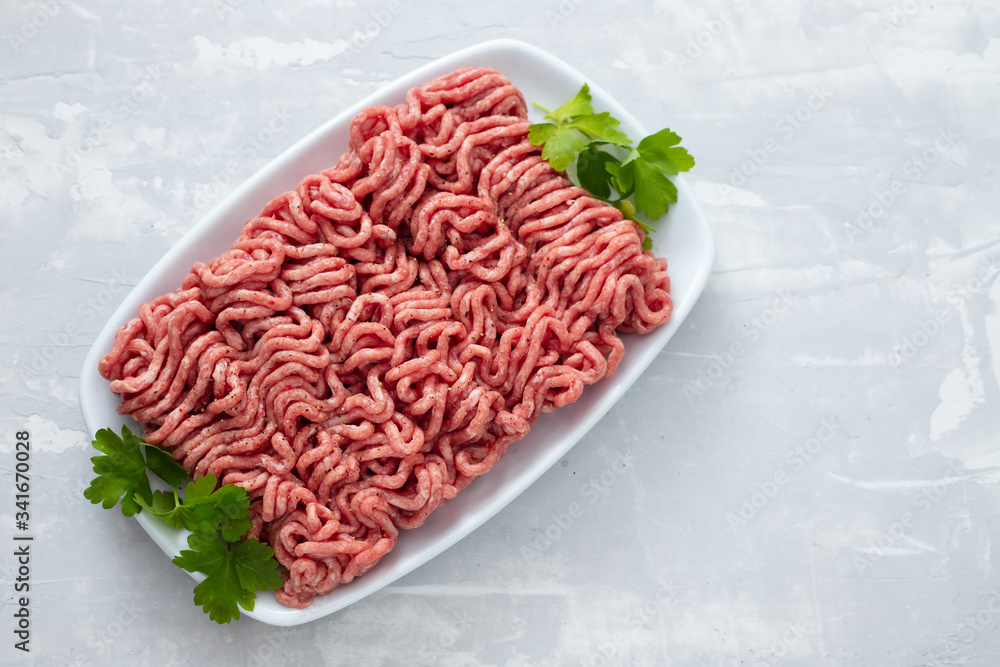 ground meat on white dish on ceramic background ground meat on white dish on ceramic background