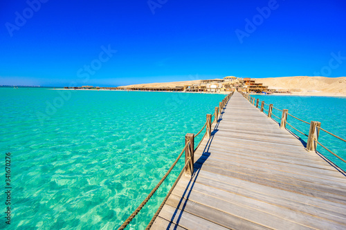 Wooden Pier at Orange Bay Beach with crystal clear azure water and white beach - paradise coastline of Giftun island  Mahmya  Hurghada  Red Sea  Egypt.