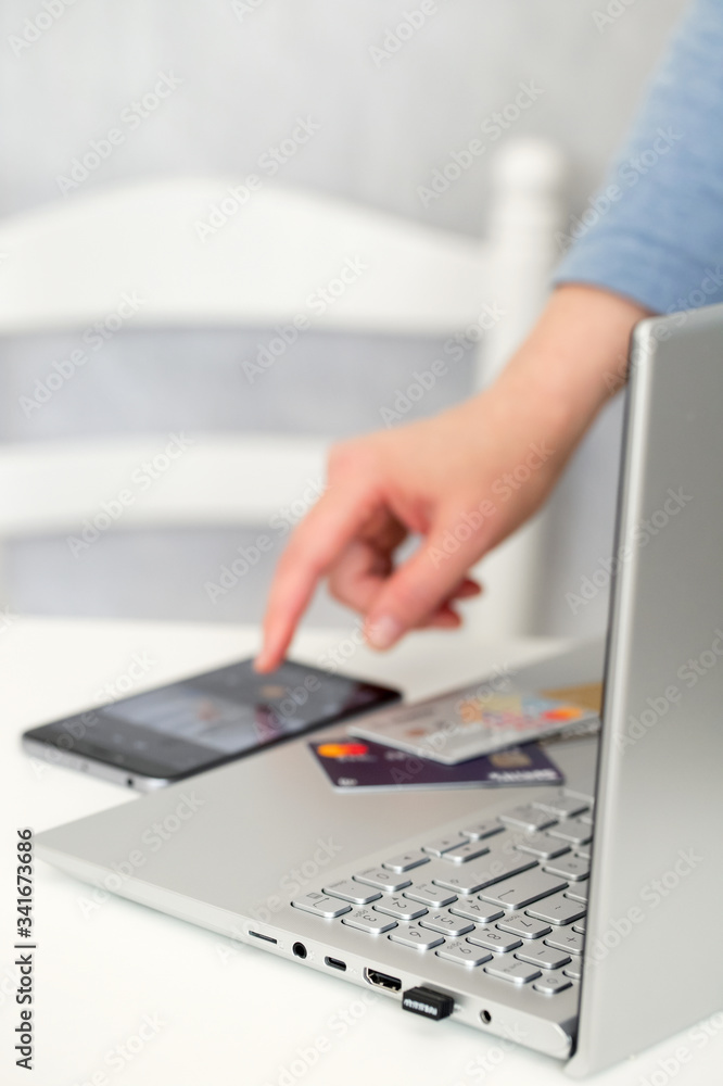 Womans hand using smartphone, credit cards and notebook Womans hand using smartphone, credit cards and notebook