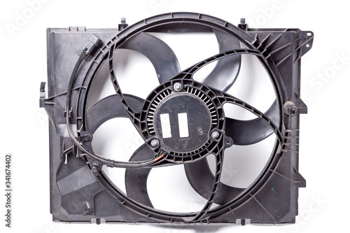 Foreground of a metal car spare part - engine radiator cooling fan on a white isolated background. Auto repair in the workshop.