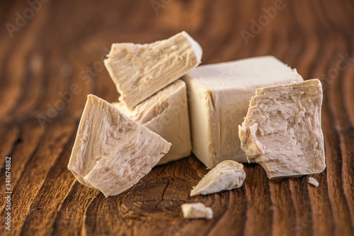 close up detail of fresh yeast cube  on a vintage old wood background 