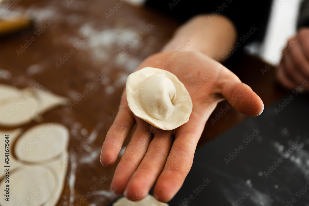 in the hand lies raw dumplings,culinary passion,traditional cooking dumplings,home food product in the hand lies raw dumplings,culinary passion,traditional cooking dumplings,home food product