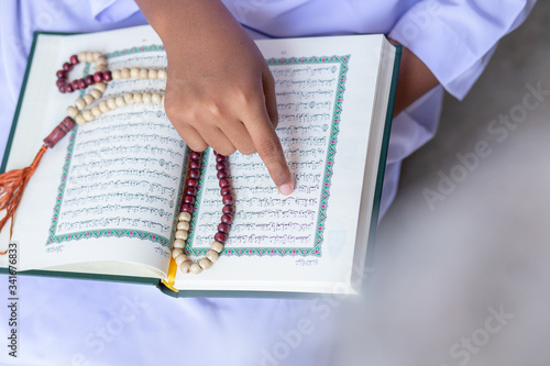 
Concept: open book holy prayers for god, Quran - holy book of Muslims religion, Friday In the month of Ramadan  religion Islamic worshiping faith and learn koran and rosary put on wooden  boards