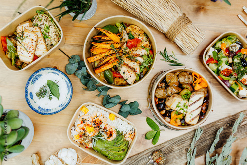 Various healthy and vitamin-rich dishes and food in an ecobox delivered by a delivery service  ordered online  decorated with bundles of straw  mussels and cacti  in a Mediterranean style