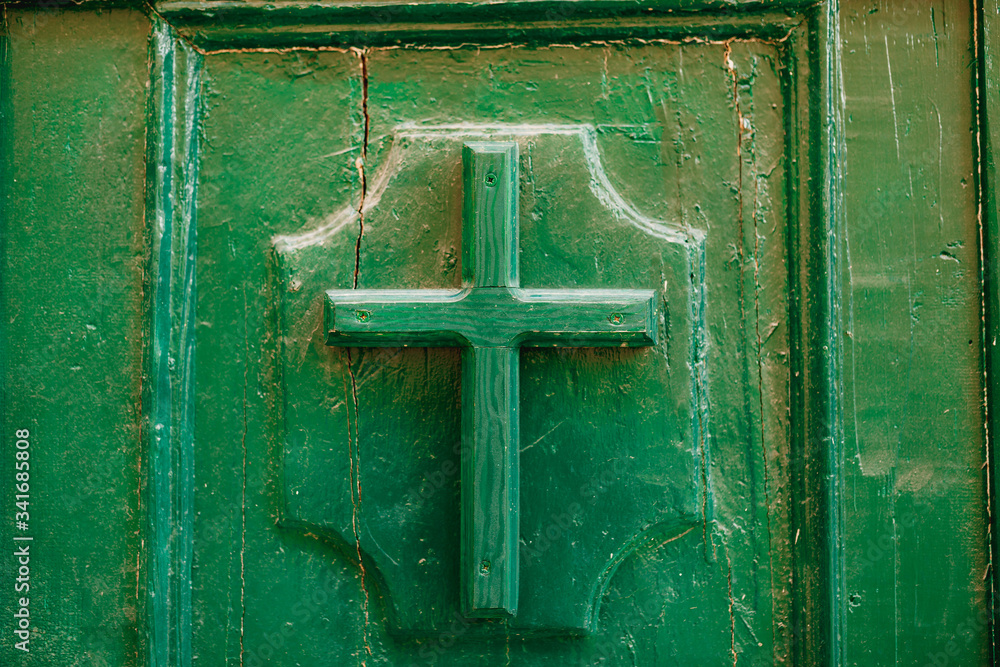 The entrance to the church. Christian cross on the door
