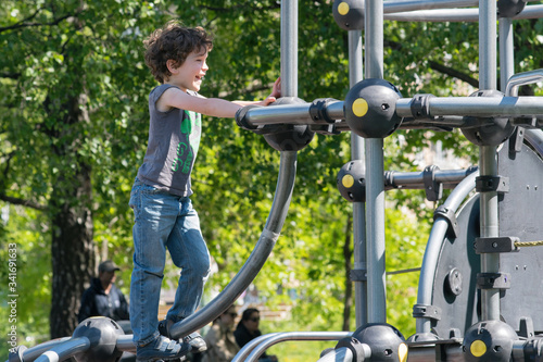 Six-year-old boy plays on the playground in the city park.