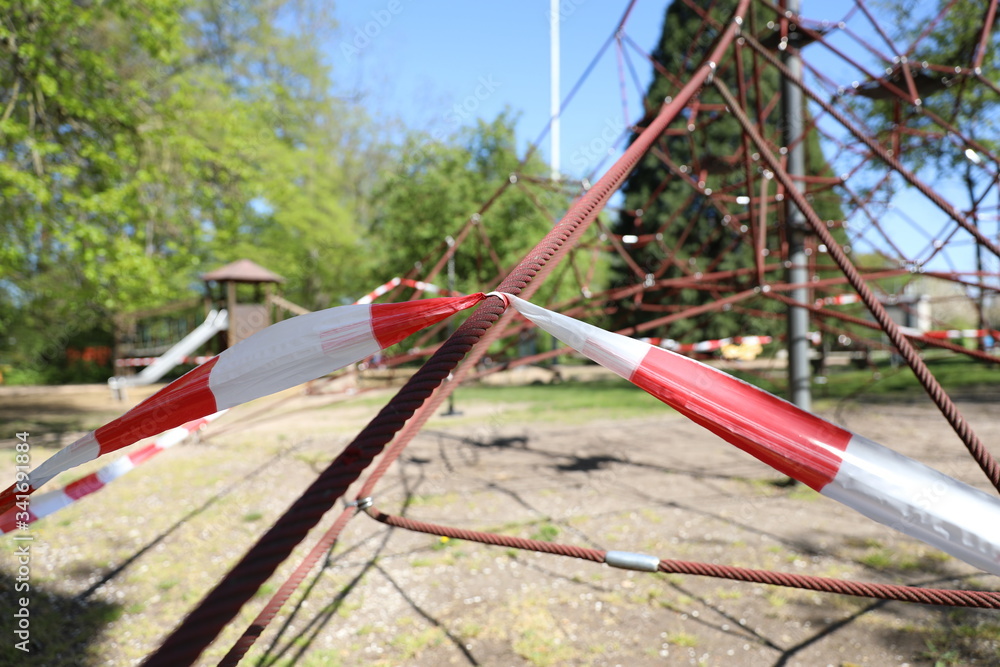 durch Corona gesperrter Kinderspielplatz mit Schaukeln durch Corona gesperrter Kinderspielplatz mit Schaukeln