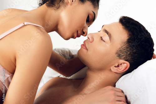 African american woman kissing handsome man in bedroom