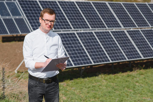 Engineer. Man near solar panel. Worker with a folder. © Serhii