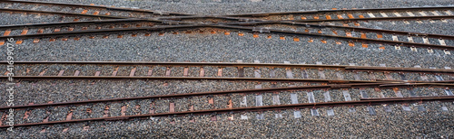 Criss-crossing heavy rail train tracks on gravel running across the frame. Railway tracks at Brisbane Roma Street