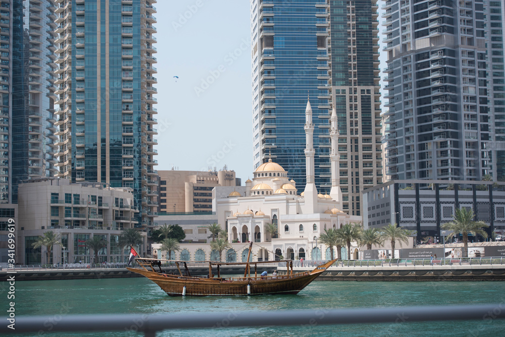 Fototapeta premium Dubai city skyline and marina with a traditional yacht 