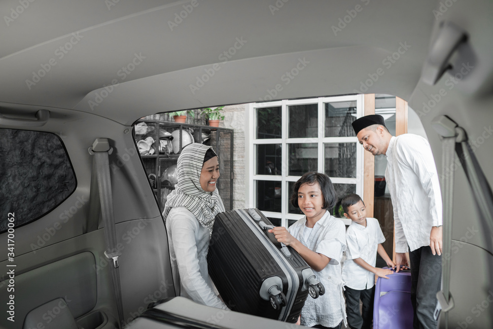 muslim family load their suitcase in to car trunk. preparing for eid mubarak holiday muslim family load their suitcase in to car trunk. preparing for eid mubarak holiday