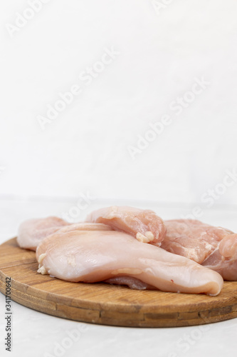 Chicken raw white meat on the wooden kitchen board with copy space