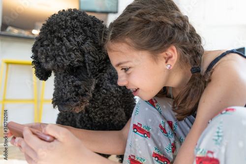 Teenage girl looking at phone with her dog