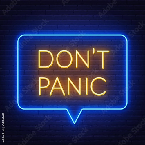 Don't panic neon lettering on brick wall background .