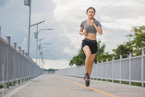 Young woman running in the nature. Healthy lifestyle and sport concepts.  Runner training in a urban area.The woman with runner on the street be running for exercise.