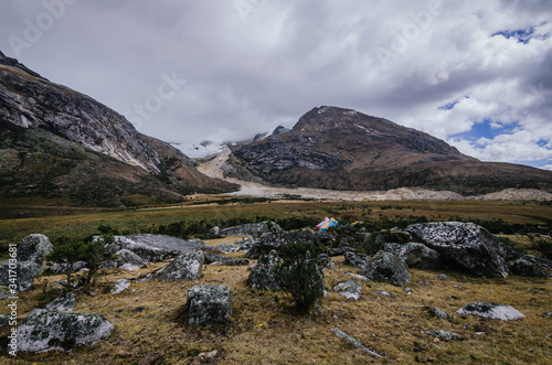 Taullipampa camp with tents and the remains of an avalanche in the background on the trekking of the quebrada santa cruz de peru