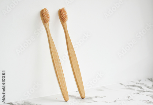 Eco-friendly bamboo toothbrush made. light gray marble surface, white background. Biodegradable personal care products. No plastic concept. Zero waste.