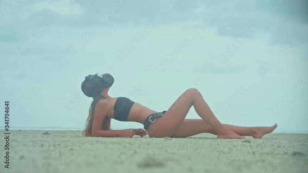 A woman with a pretty body wears a gas mask on the beach A woman with a pretty body wears a gas mask on the beach