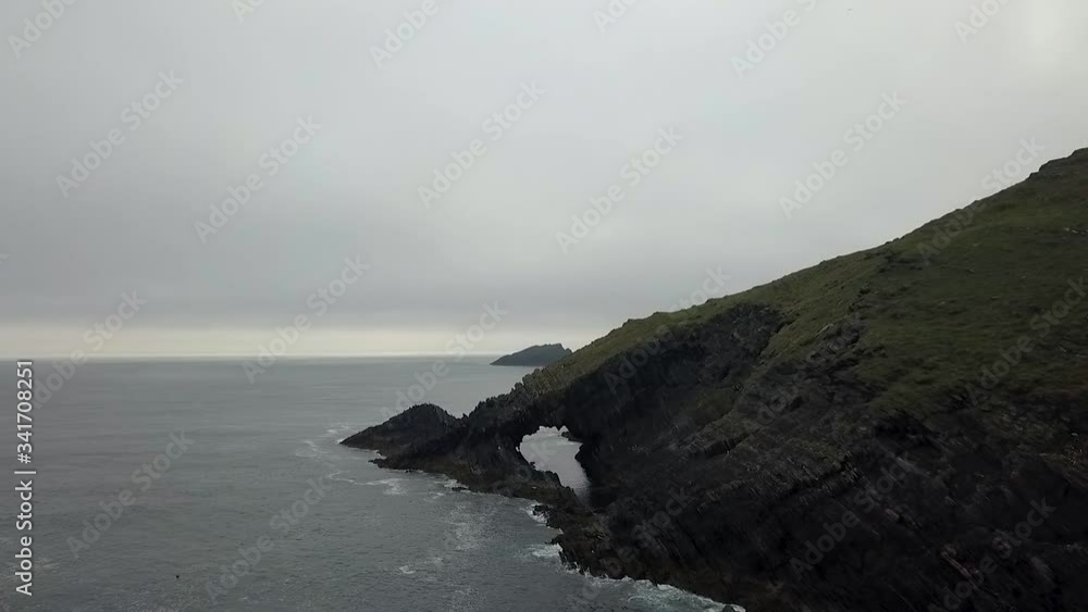 Flyover Irish misty coast with natural archway Flyover Irish misty coast with natural archway