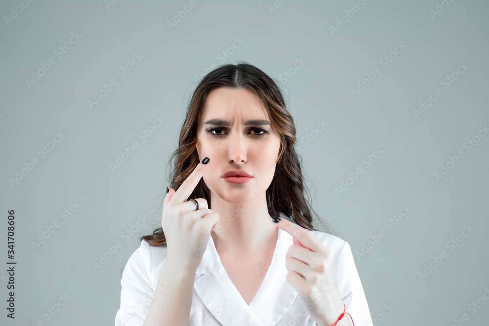 People, cosmetology, plastic surgery and beauty concept - surgeon or beautician hands touching woman face over white background People, cosmetology, plastic surgery and beauty concept - surgeon or beautician hands touching woman face over white background
