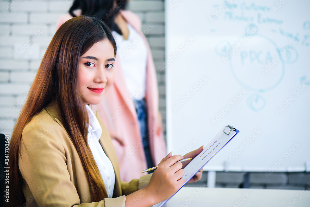 Young confident Asian business woman smiling and sitting in front of business team meeting or brainstorming at office. Teamwork meeting and partnership conference working concept. Young confident Asian business woman smiling and sitting in front of business team meeting or brainstorming at office. Teamwork meeting and partnership conference working concept.