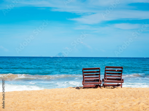 Chairs on the beach near ocean. Winter vacation in hot places. Sunshine and moody sky © Dmytro