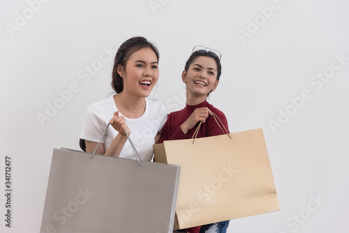 Happy asian shopping woman hold shopping bags in hand enjoy in lifestyle shopping concept, in midnight sales and discount on seales. photo