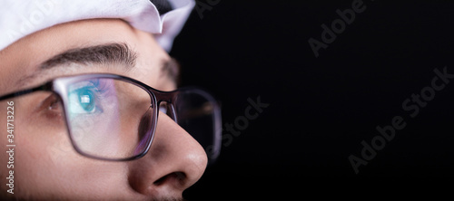 Focused and thoughtful Arab man in dark. macro of glasses of confident Arabic young male. isolated on black background.