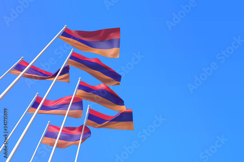 Armenia flags waving in the wind against a blue sky. 3D Rendering