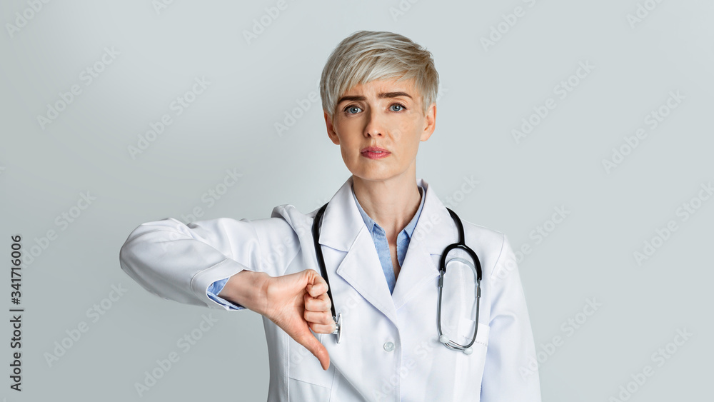 Sad woman doctor shows with hand dislike Sad woman doctor shows with hand dislike