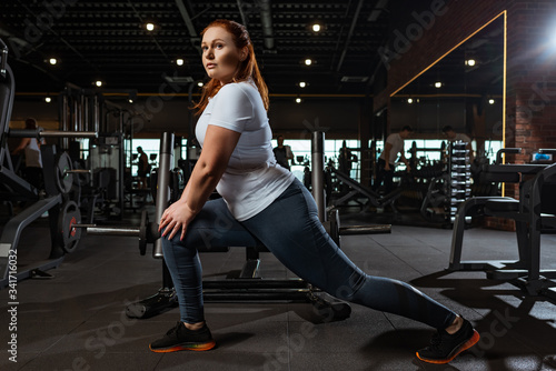 Φωτογραφία pretty, overweight girl doing lounges exercise in gym