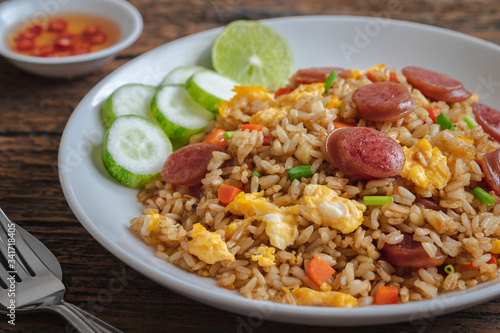 Fried rice with chinese sausage on plate and chili fish sauce.