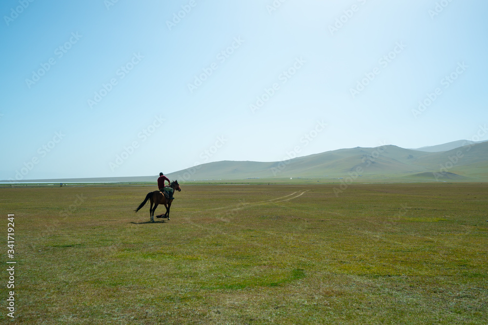 Horse riders playing a game of Kok Buro, a traditional game also known as dead goat polo, on Song Kul plateau in central Kyrgyzstan