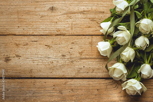 White roses on a background of old wooden boards. Vintage. Frame. Congratulation