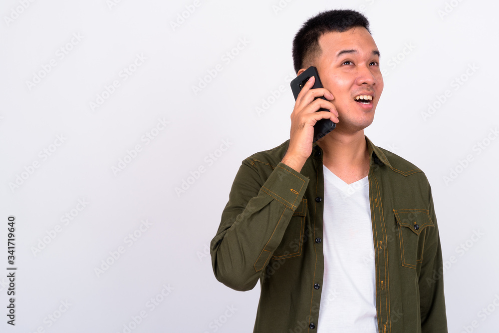 Portrait of happy young Asian man talking on the phone Portrait of happy young Asian man talking on the phone